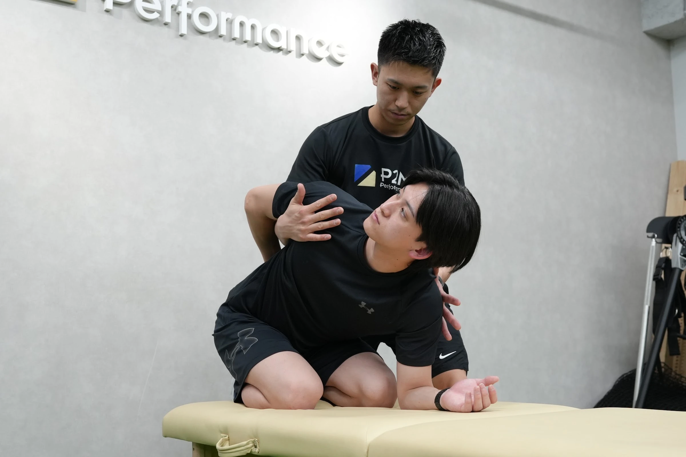 ベッド上で利用者の肩と体幹の動きをサポートするコンディショニング