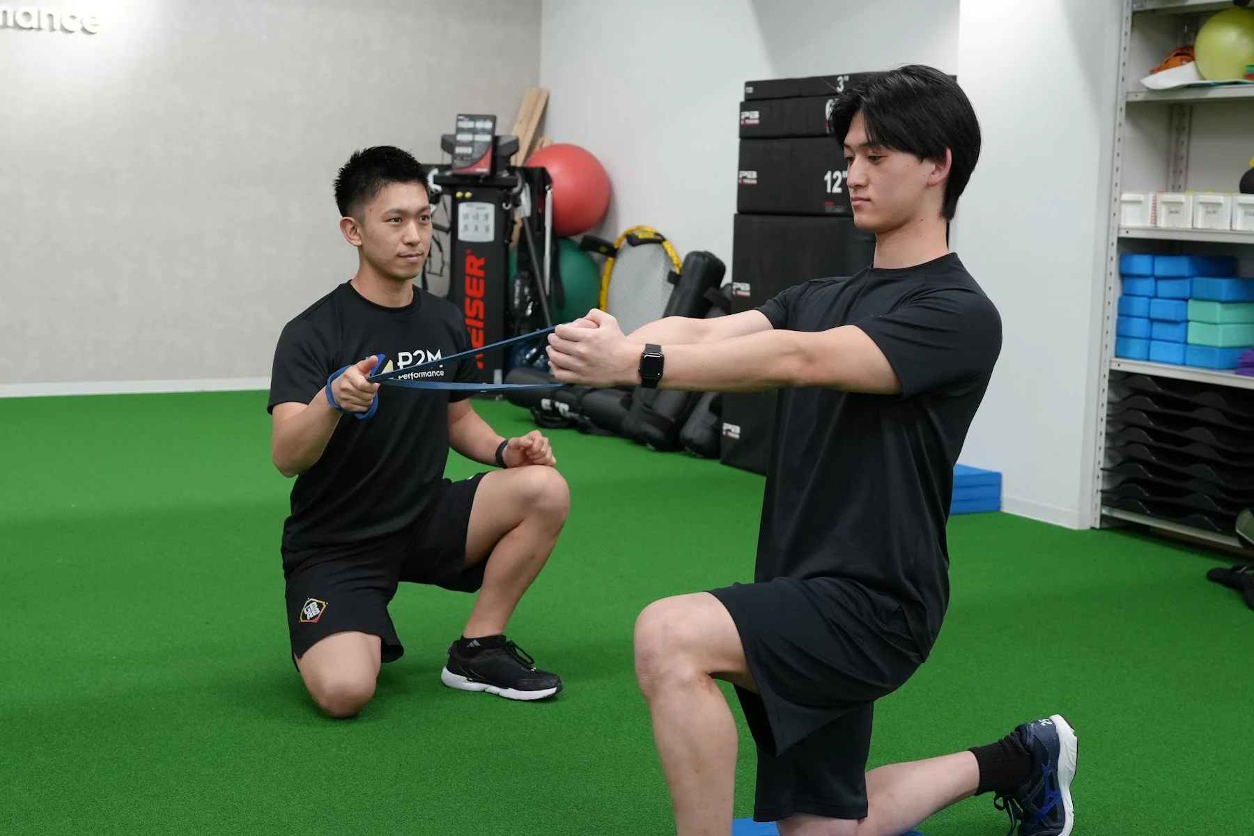 コーチが横でフォームを確認するマンツーマンのトレーニング